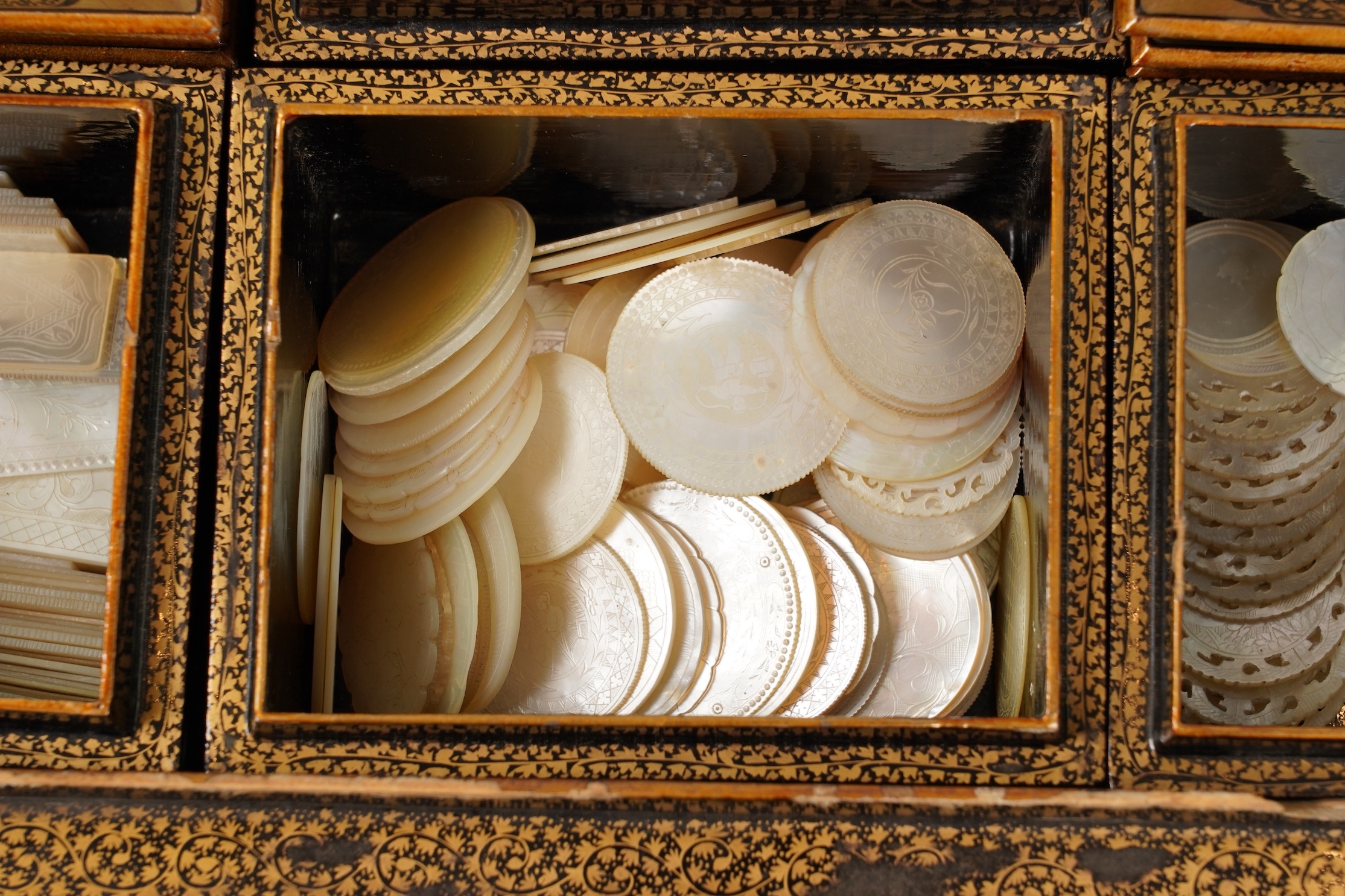 Two Chinese gilt decorated black lacquer games boxes, containing numerous mother-of-pearl counters, 19th century